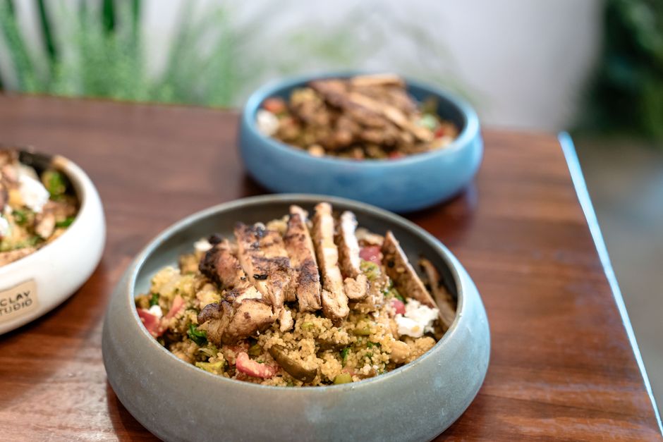 A delectable quinoa salad with succulent grilled chicken served in stylish ceramic bowls on a wooden table.